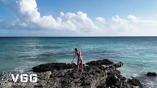 A young and sexy girl is playing on the naked beach