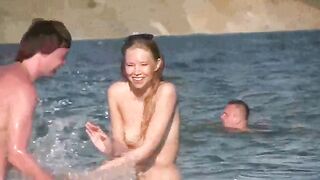 A mature woman sunbathes on the bare beach