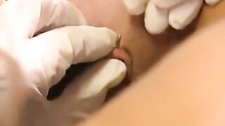 A woman with a clit piercing plays with a large toy in her pussy