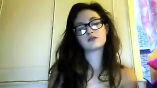 A cute student with glasses gets undressed during a video call