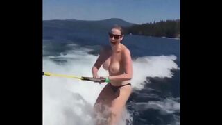 Topless girl has fun on the water while skiing