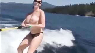 Topless girl has fun on the water while skiing