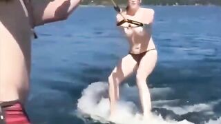 Topless girl has fun on the water while skiing