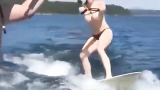 Topless girl has fun on the water while skiing