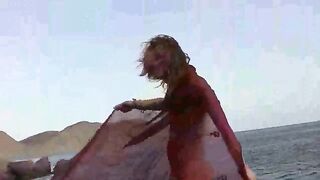 A sexy girl is walking on the wet beach almost naked