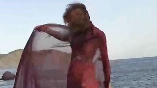 A sexy girl is walking on the wet beach almost naked