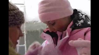 Two girls have fun in the snow on a cold winter day