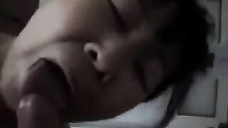 An old Chinese woman practices her blowjob skills on a young guy’s bed