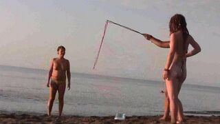 A naked girl is having fun on the beach without any clothes