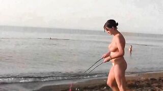 A naked girl is having fun on the beach without any clothes