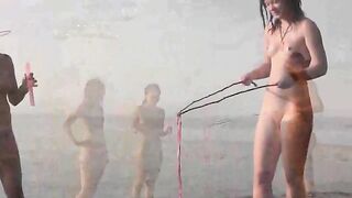 A naked girl is having fun on the beach without any clothes