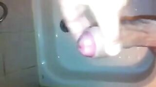 The kid stands in the shower and jerks off his dick with his hand until the end
