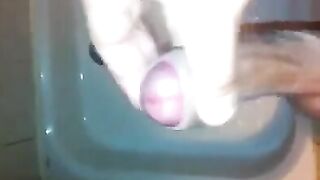 The kid stands in the shower and jerks off his dick with his hand until the end