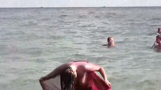 A naked girl is having bath in the sea