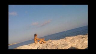 A young girl sunbathes naked on the beach. It's not forbidden