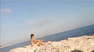 A young girl sunbathes naked on the beach. It's not forbidden
