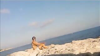 A young girl sunbathes naked on the beach. It's not forbidden