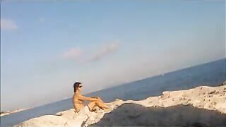 A young girl sunbathes naked on the beach. It's not forbidden