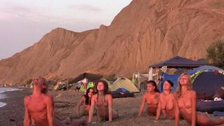 A cheerful girl is having fun with friends on naked beach
