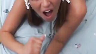 A blonde with glasses is standing on her boobies, delivering an incredible oral performance