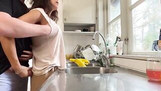 A mature woman with big tits is being fucked in the kitchen